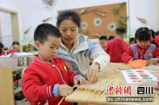 老師指導幼兒園小朋友編竹編。劉龍泉 攝 老師指導幼兒園小朋友編竹編。劉龍泉 攝