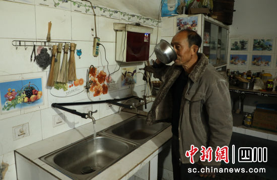 兩合村村民李中華開心地喝著自來水。長寧縣融媒體中心供圖。 兩合村村民李中華開心地喝著自來水。長寧縣融媒體中心供圖。