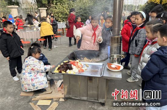 學生正在炒菜。 什邡外國語小學供圖 學生正在炒菜。 什邡外國語小學供圖