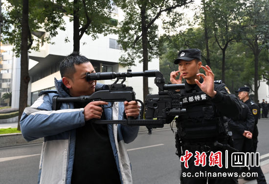 民警向市民講解警用槍支知識。記者安源攝 民警向市民講解警用槍支知識。記者安源攝