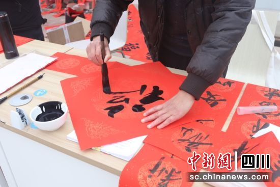 為工友們寫春聯(lián)和“福”字。成都東部新區(qū) 供圖 為工友們寫春聯(lián)和“福”字。成都東部新區(qū) 供圖