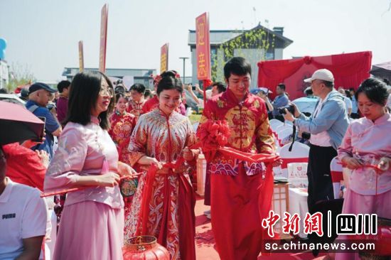 新人現場體驗傳統婚俗禮儀。郫都區融媒體中心 供圖 新人現場體驗傳統婚俗禮儀。郫都區融媒體中心 供圖