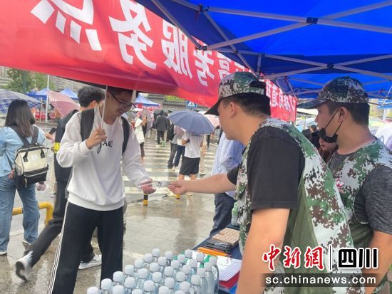 志愿隊隊員為考生發放飲用水。劉怡 攝 志愿隊隊員為考生發放飲用水。劉怡 攝