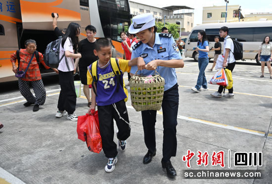 東莞市大朗鎮公安分局接站民警幫助小乘客拿行李。四川公安供圖 東莞市大朗鎮公安分局接站民警幫助小乘客拿行李。四川公安供圖