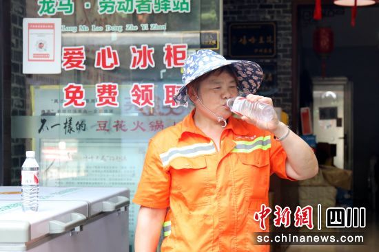 環(huán)衛(wèi)工在愛心冰柜前喝水。謝汶萍 攝 環(huán)衛(wèi)工在愛心冰柜前喝水。謝汶萍 攝