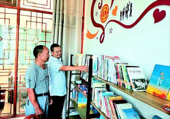 全國勞動模范楊華順(左)在景區工會驛站書屋了解藏書情況 全國勞動模范楊華順(左)在景區工會驛站書屋了解藏書情況