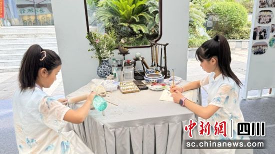 郭鑫愉(右)正在進行花鳥畫創作。劉倩 攝 郭鑫愉(右)正在進行花鳥畫創作。劉倩 攝