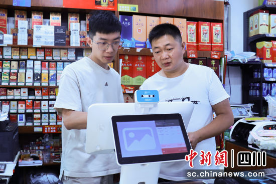 客戶經理指導王小斌(右)使用智慧收銀機。顏美芹 攝 客戶經理指導王小斌(右)使用智慧收銀機。顏美芹 攝