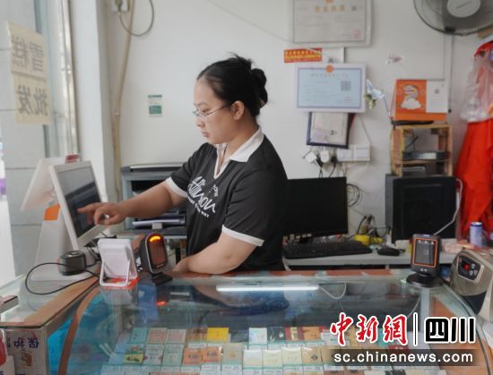 零售戶熊雪梅使用收銀機查看銷售數據。余婉霜 攝 零售戶熊雪梅使用收銀機查看銷售數據。余婉霜 攝